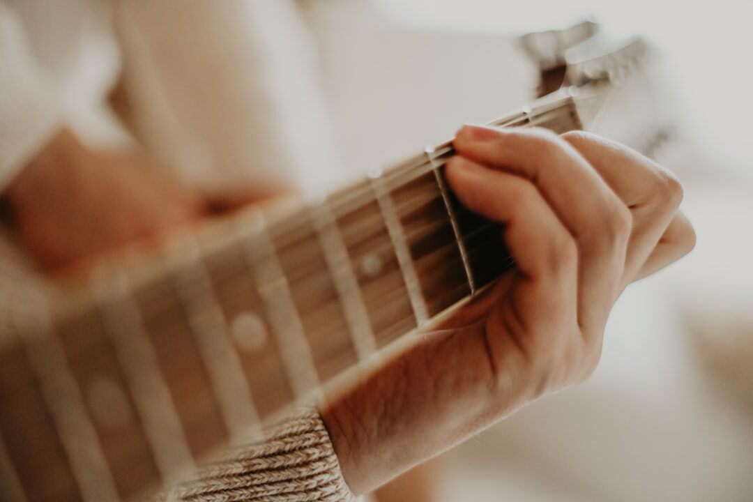 musician playing acoustic guitar